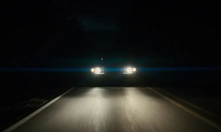 Night road seen through a car windshield