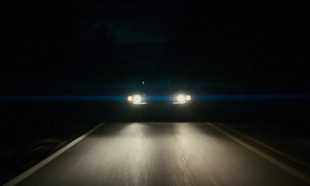 Night road seen through a car windshield