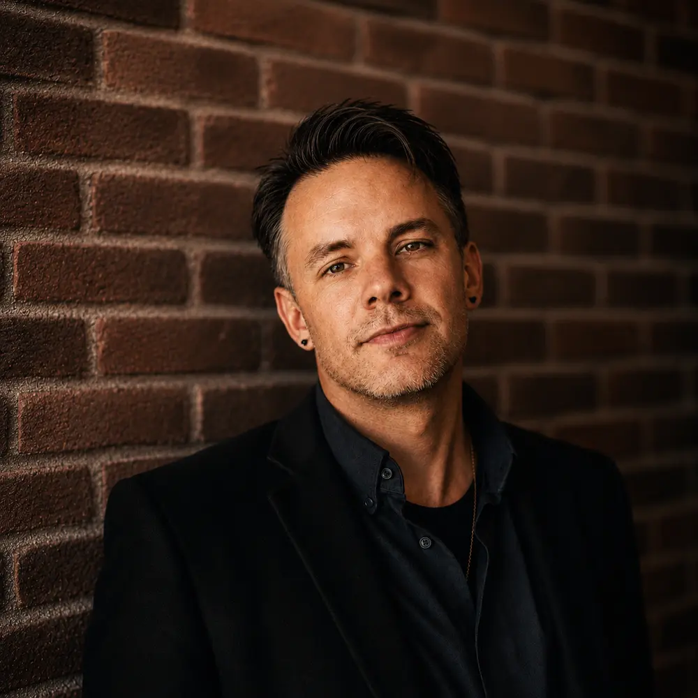 Portrait of Christopher Shank against a brick wall