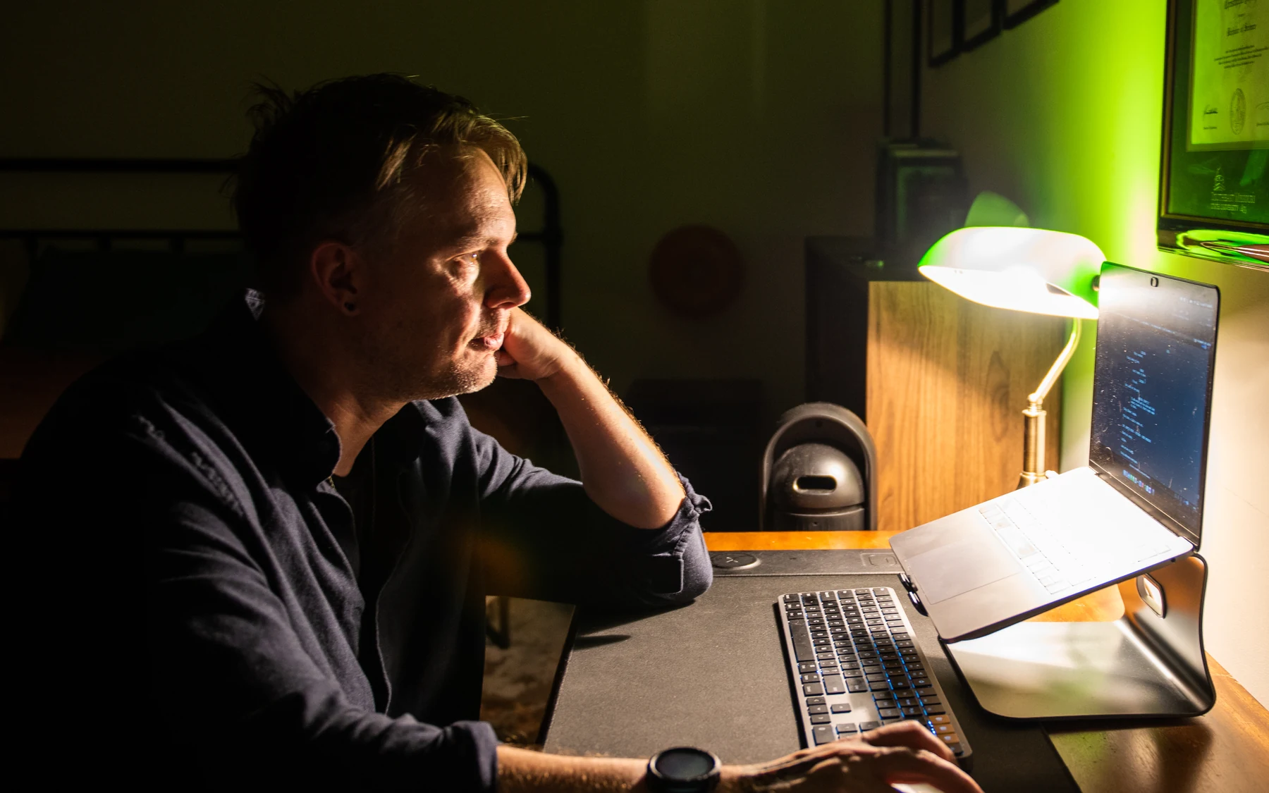 Christopher Shank writing at his computer in profile.