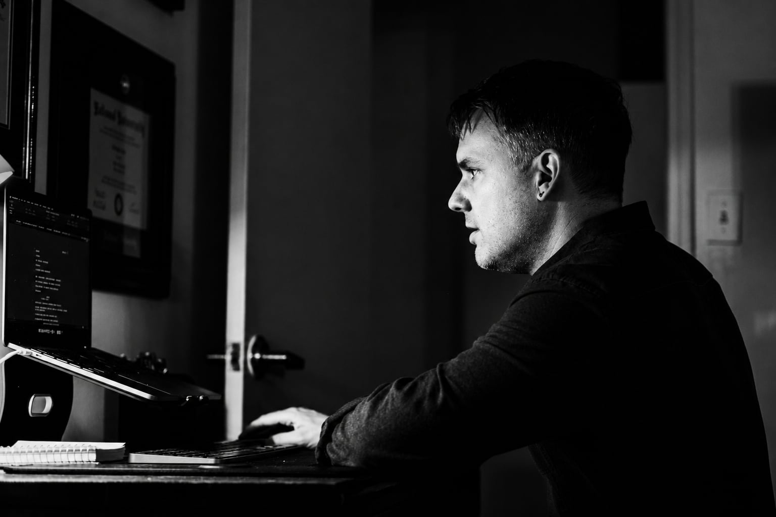 Christopher Shank writing at his computer in profile.